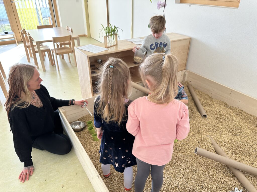 Kinder der städtischen Kita Schneckenhaus spielen im neuen Bohnenbad. Einem Spielplatz gefüllt mit Sojabohnen. 